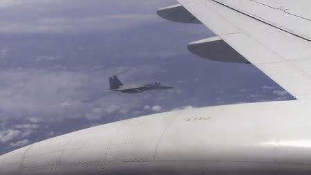 A Japanese F-15 jet (background) and a Chinese Tu-154 jet (foreground) fly over the East China Sea, in this still image from video footage released by China's Ministry of Defense on June 12, 2014. REUTERS/Ministry of National Defense of the People's Republic of China/via Reuters TV