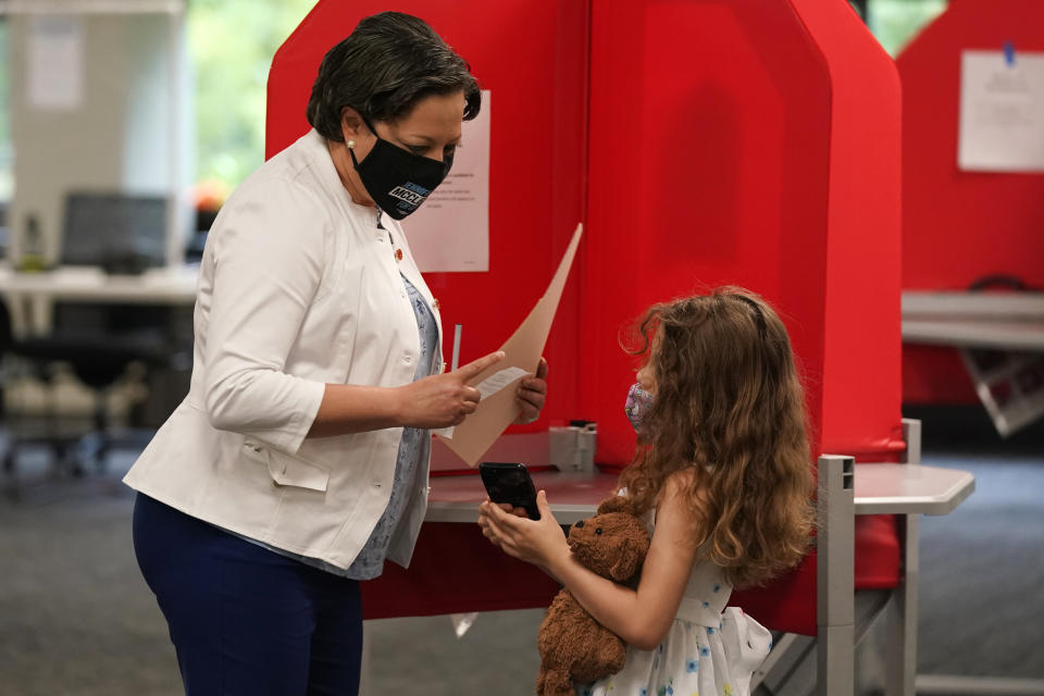 Democratic gubernatorial candidate, Virginia State Sen. Jennifer McClellan, left, shows her daughter Samantha, right, her ballot at an early voting location in Richmond, Va., Saturday, May 29, 2021. McClellan faces four other Democrats in the primary. (AP Photo/Steve Helber)