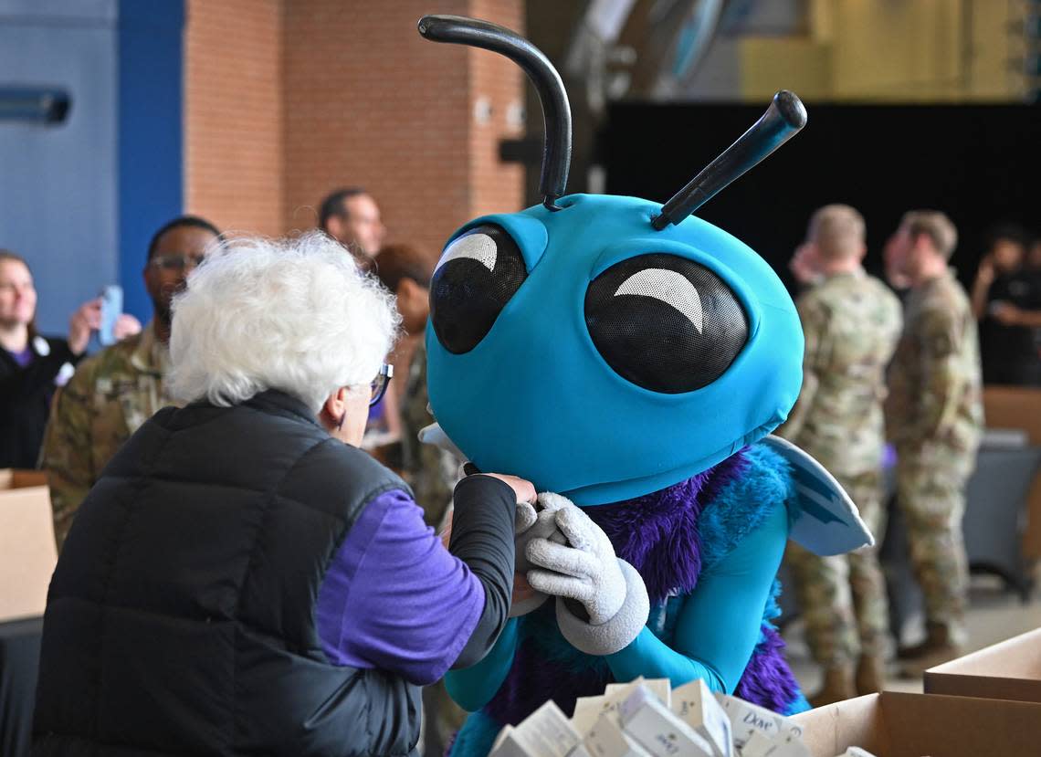 Charlotte Hornets mascot Hugo, right, playfully kisses the hand of a Novant Health worker during the team’s 10th annual Military Care event at Spectrum Center in Charlotte, NC on Monday, March 4, 2024. The Hornets and Novant Health assemble 3,000 care kits for U.S. military service members during the event.