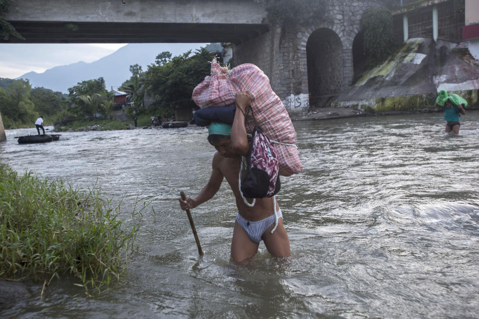 Men carry loads of supplies as they cross the Suchiate river from Guatemala into Talisman, Mexico, Friday, June 21, 2019. Mexico's foreign minister says that the country has completed its deployment of some 6,000 National Guard members to help control the flow of Central American migrants headed toward the U.S.(AP Photo/Oliver de Ros)