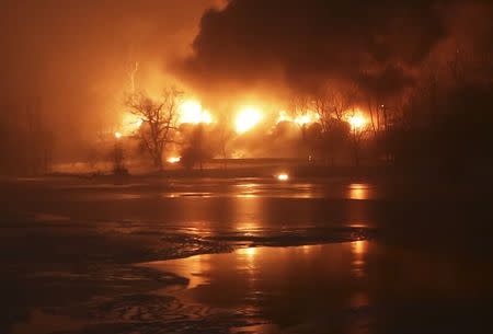 A CSX Corp train burns after derailment in Mount Carbon, West Virginia pictured across the Kanawha River in Boomer, West Virginia February 16, 2015. REUTERS/Marcus Constantino