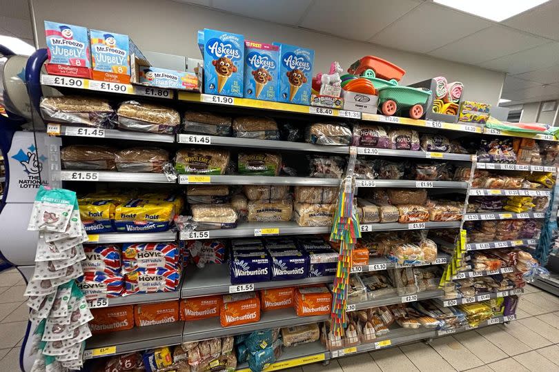Bread shelf with variety of lines and brands for sale including Hovis and Warburtons, Tesco Express, Radcliffe-on-Trent