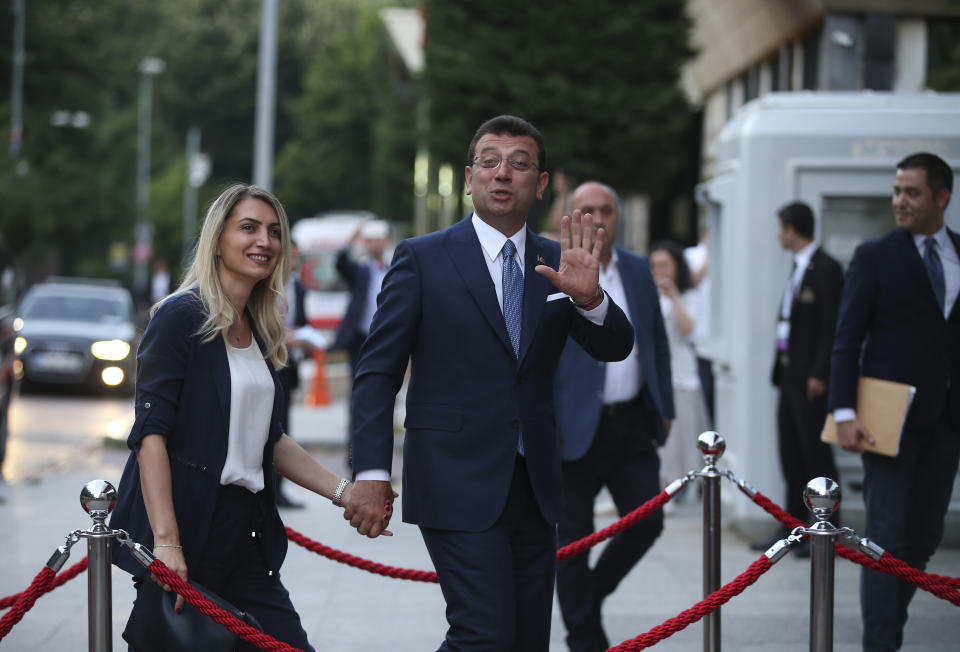 Istanbul's mayoral candidate Ekrem Imamoglu, candidate of the secular opposition Republican People's Party, or CHP, accompanied by his wife, name not given, arrives for a televised debate with Binali Yildirim, of Turkey's ruling Justice and Development Party, or AKP, ahead of the June 23 re-run of Istanbul elections, Sunday, June 16, 2019. Televised election debates are uncommon in Turkey. The last one, between AKP leader Recep Tayyip Erdogan and the then-leader of the CHP, took place before a 2002. The AKP has been in power since. (AP Photo/Emrah Gurel)
