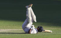 India's Rishabh Pant falls as he hits the ball for four runs during play on the final day of the fourth cricket test between India and Australia at the Gabba, Brisbane, Australia, Tuesday, Jan. 19, 2021. (AP Photo/Tertius Pickard)