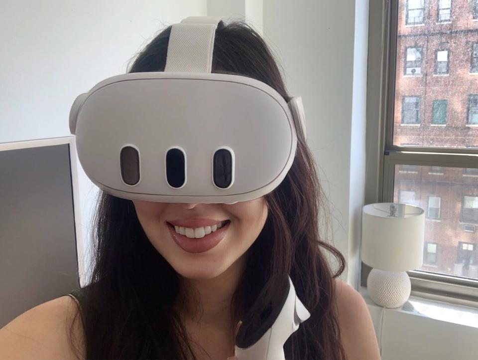 Selfie of the author wearing a white Meta VR headset with three small windows on the surface. The writer is holding a controller