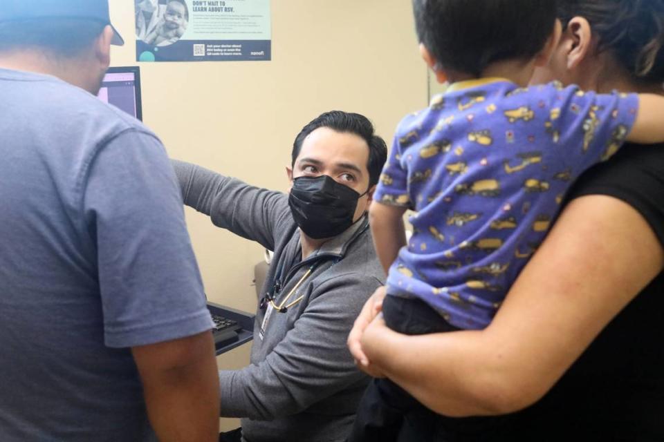 El doctor pediatra Rodrigo De la Cruz explica a los padres de su paciente la revisión que le hizo a niño en la clínica Altura Centers for Healths en el oeste de Tulare el 7 de septiembre del 2023./ Pediatrician Dr. Rodrigo De la Cruz explains to his patient’s parents the checkup he performed on their child at the Altura Centers for Healths clinic in west Tulare on September 7, 2023.