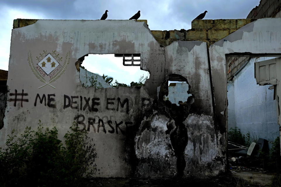 Graffiti scrawled on the wall of an abandoned home reads in Portuguese; "Leave me in peace Braskem," in the Farol neighborhood of Maceio, Alagoas state, Brazil, Sunday, March 6, 2022. Farol is one of the neighborhoods that has been abandoned because of the threat of ground subsidence caused by the Braskem mine. (AP Photo/Eraldo Peres)