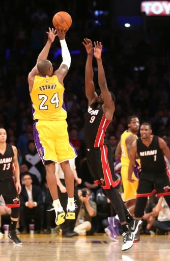 Kobe Bryant of the Los Angeles Lakers shoots a 3-point attempt at the buzzer over Luol Deng of the Miami Heat in 2015