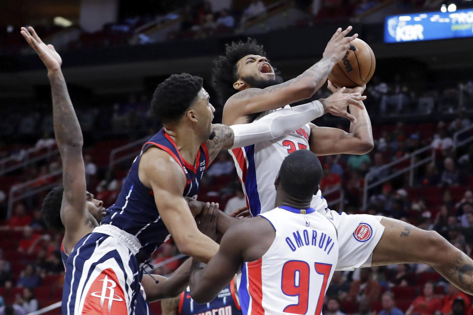 Detroit Pistons forward Marvin Bagley III, top right, is fouled on his shot attempt by Houston Rockets forward K.J. Martin, top left, during the first half of an NBA basketball game Friday, March 31, 2023, in Houston. (AP Photo/Michael Wyke)