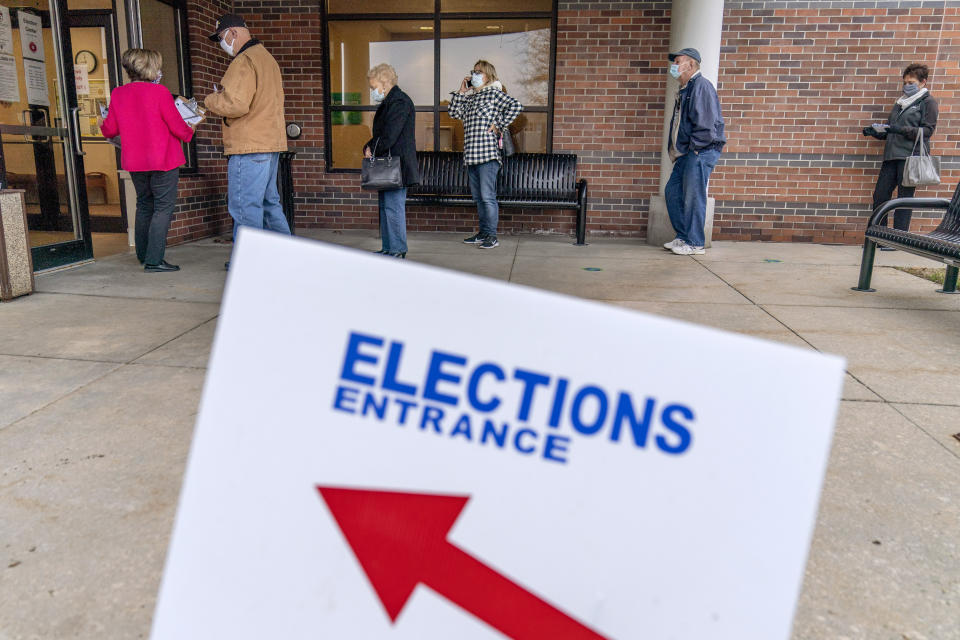 In this Oct. 29, 2020, photo, voters line up as the doors open to the Election Center for absentee early voting for the general election in Sterling Heights, Mich. President-elect Joe Biden shored up the Democrats' “blue wall,” — more sturdily in Michigan, more tenuously in Pennsylvania and Wisconsin — to rebuild the party's path back to the White House. (AP Photo/David Goldman)