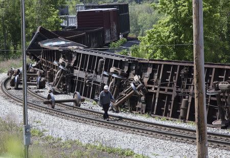An investigator surveys a freight train derailment involving at least 10 cars which left the tracks in Pittsburgh, Pennsylvania May 14, 2015. REUTERS/John Altdorfer