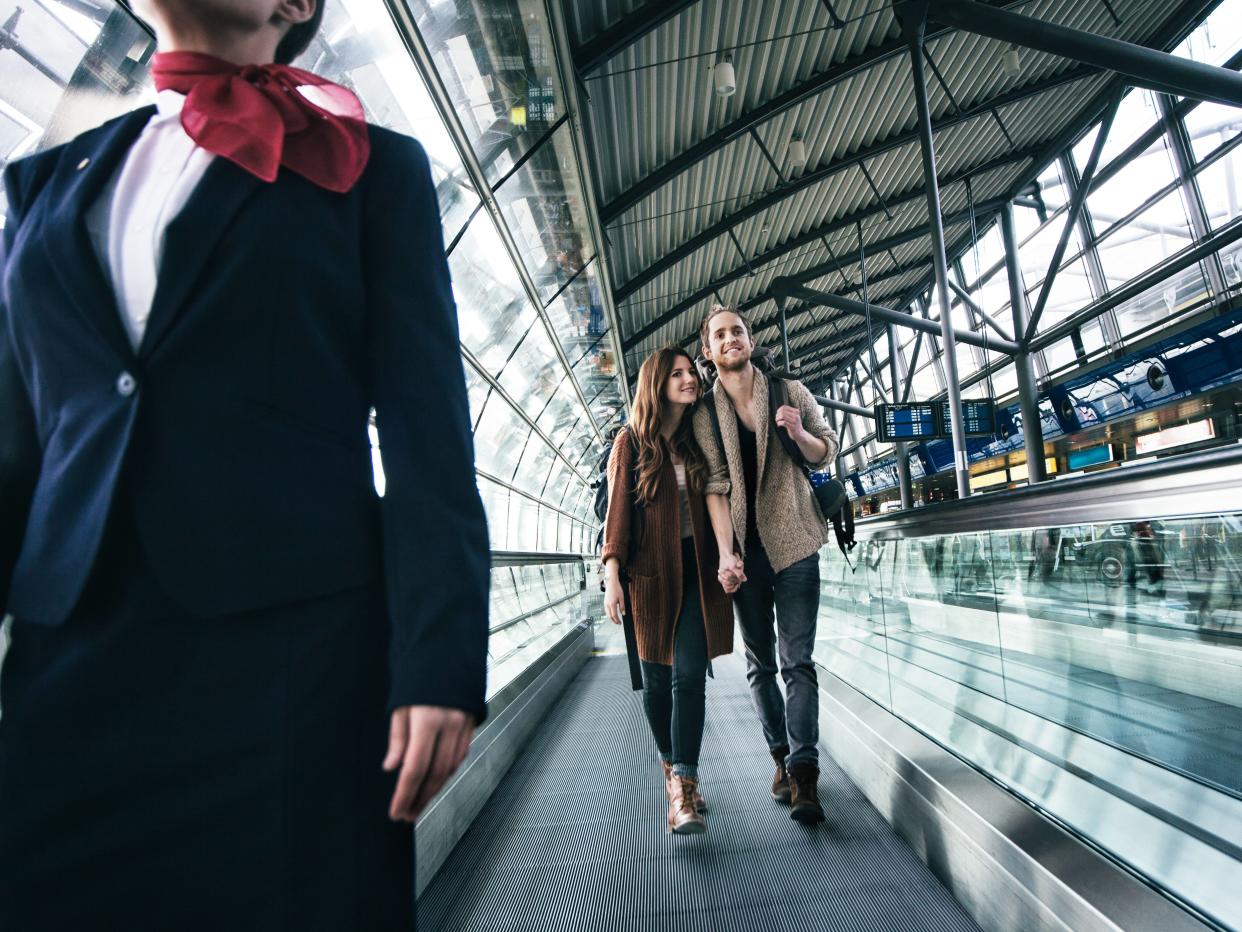 Illustrative photo of a flight attendant and a couple at an airport.