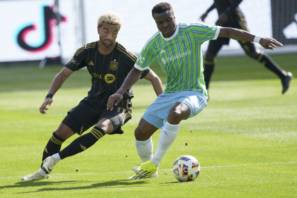 Seattle Sounders defender Nouhou Tolo, right, and Los Angeles FC midfielder Timothy Tillman, left, fight for a ball during the first half of an MLS soccer match, Saturday, Feb. 24, 2024, in Los Angeles. (AP Photo/Eric Thayer)