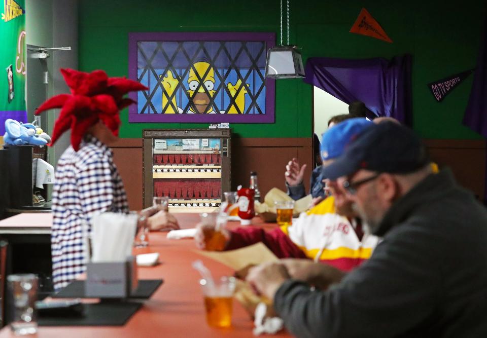 Homer appears to be left on the outside looking in as Simpsons fans warm up with a drink at Moe's pop-up bar inside Missing Falls Brewery Friday in Akron.