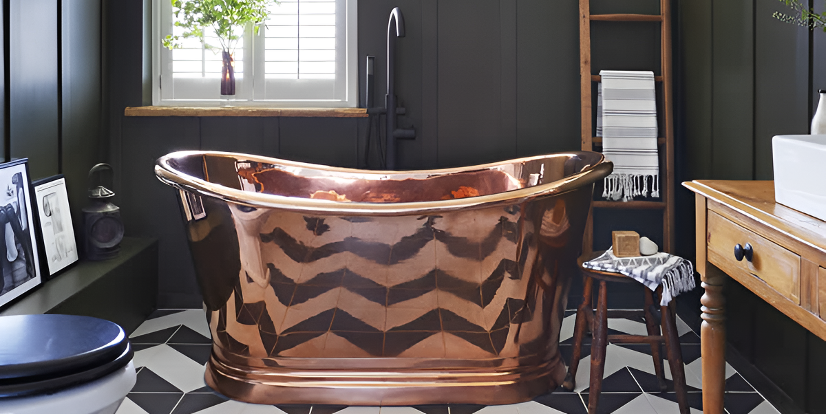 a large copper freestanding bathtub in a bathroom with wall panelling and monochrome, black and white, floor tiles