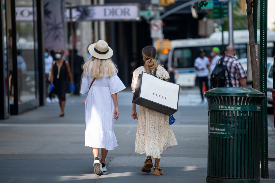 NEW YORK, NEW YORK - JUNE 24: A woman carries a mask and a Gucci shopping bag down a street as the city moves into Phase 2 of re-opening following restrictions imposed to curb the coronavirus pandemic on June 24, 2020 in New York City. Phase 2 permits the reopening of offices, in-store retail, outdoor dining, barbers and beauty parlors and numerous other businesses. New York state plans on re-opening in four phases. (Photo by Alexi Rosenfeld/Getty Images)