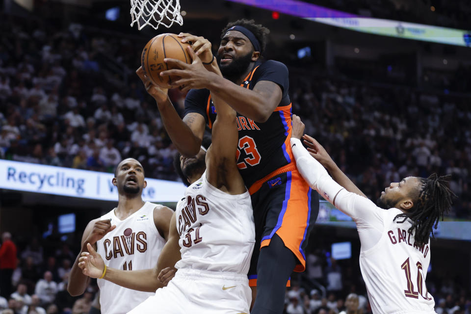 New York Knicks center Mitchell Robinson (23) works for a rebound against Cleveland Cavaliers center Jarrett Allen (31), guard Darius Garland (10) and forward Evan Mobley (4) during the second half of Game 2 of an NBA basketball first-round playoff series Tuesday, April 18, 2023, in Cleveland. (AP Photo/Ron Schwane)