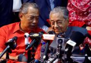 Former Malaysia's Prime Minister Mahathir Mohamad listens to former Malaysian Deputy Prime Minister Muhyiddin Yassin during a news conference following the temporary deregistration of Parti Pribumi Bersatu Malaysia (PPBM) in Petaling Jaya,