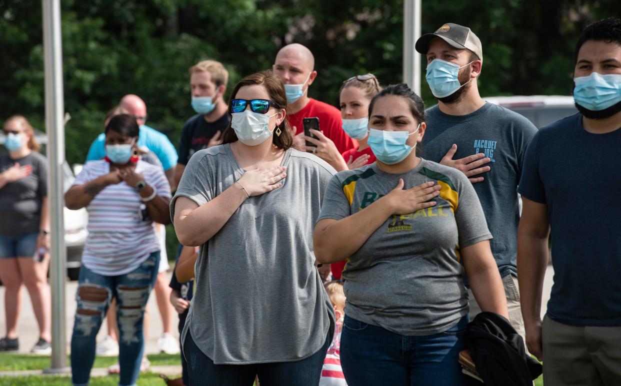 Parents and guests of students wear face masks and keep a distance from the children and teachers at the Stepping Stone School annual parking lot Fourth of July parade on July 3, 2020 in Tyler, Texas. Gov. Greg Abbott's new statewide mask mandate went into effect on Friday.