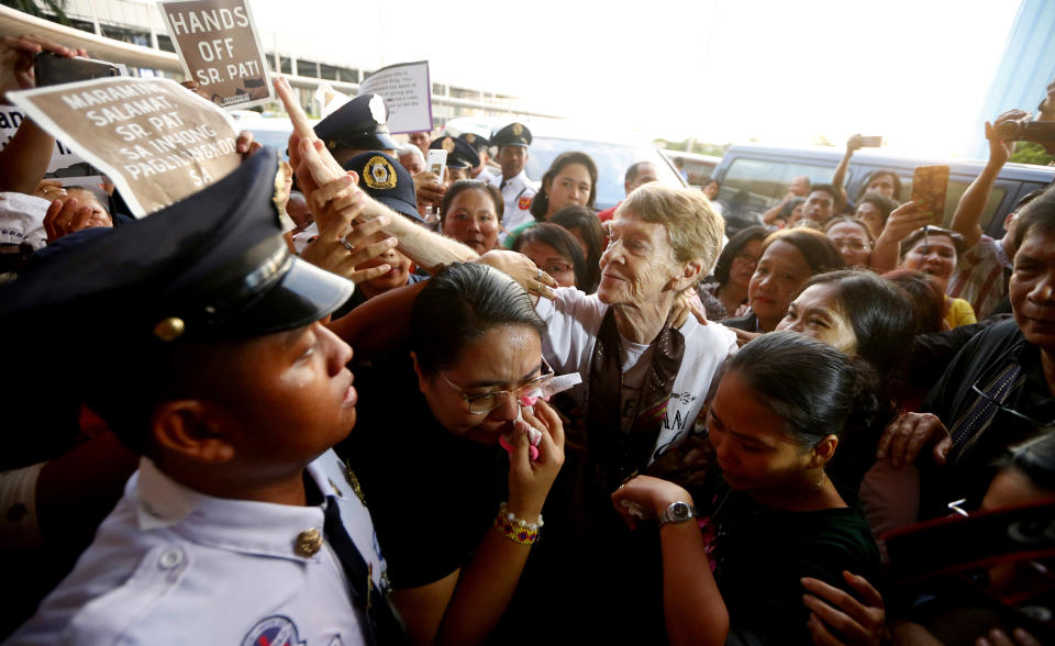 Australian Roman Catholic nun Sister Patricia Fox reaches out to bid goodbye to supporters as she is escorted to the Ninoy Aquino International Airport for her flight to Australia Saturday, Nov. 3, 2018, in Manila, Philippines. Sister Fox decided to leave after 27 years in the country after the Immigration Bureau denied her application for the extension of her visa. Sr. Fox called on Filipinos to unite and fight human rights abuses ahead of her forced departure from the country. (AP Photo/Bullit Marquez)