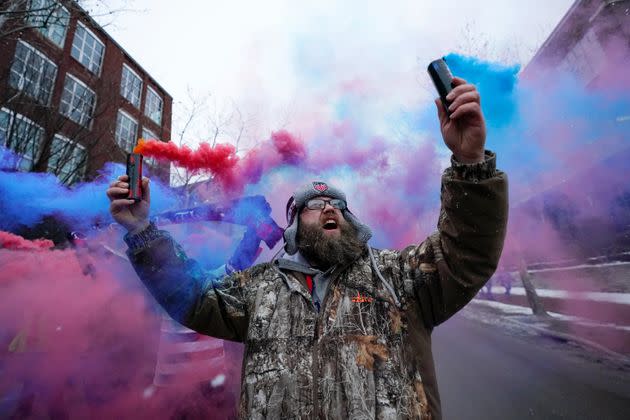 Scott Spencer holds colorful flares on Thursday as he and a group of United States men's national soccer team supporters march ahead of a FIFA World Cup qualifying soccer match against El Salvador in Columbus, Ohio. (Photo: Julio Cortez / AP)