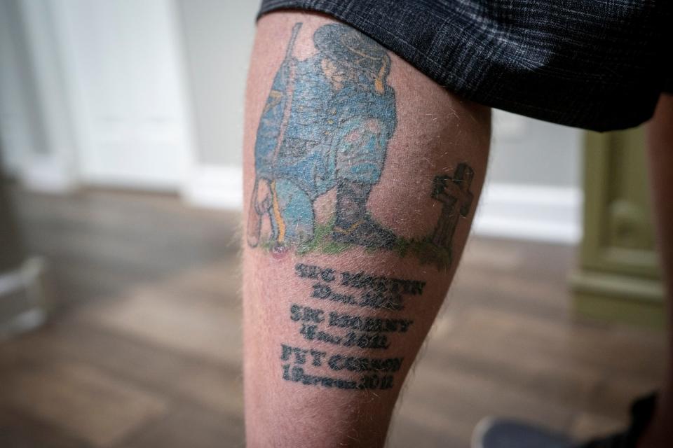 Daniel Berry, a former member of the Wisconsin chapter of the Proud Boys, shows a tattoo on his leg memorializing his fallen military brothers.