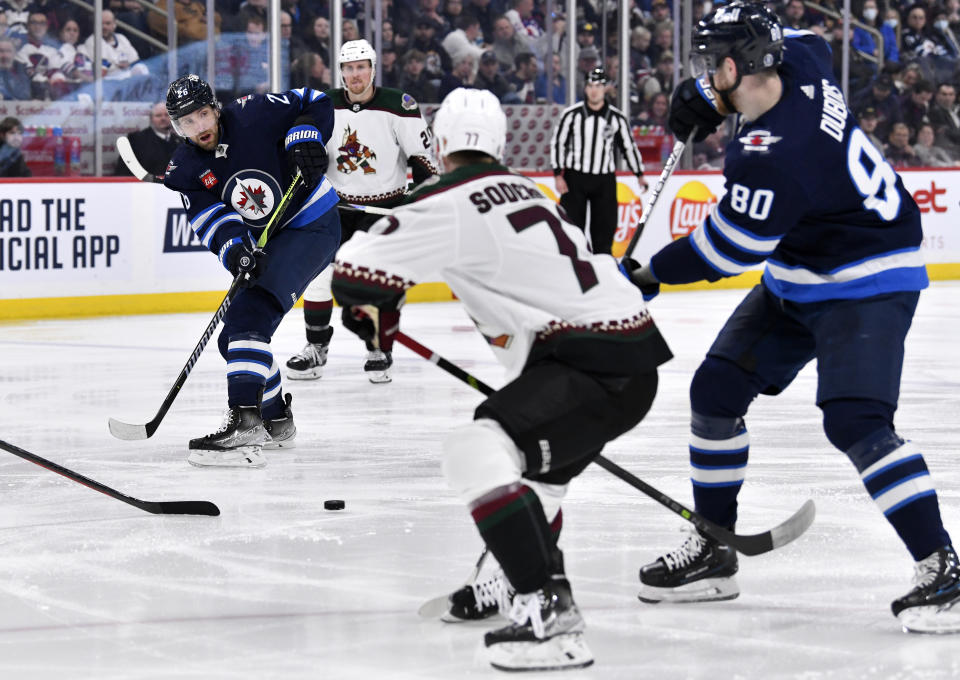 Winnipeg Jets' Pierre-Luc Dubois (80) passes the puck to Blake Wheeler (26) past Arizona Coyotes' Victor Soderstrom (77) during the second period of an NHL hockey game, Tuesday, March 21, 2023 in Winnipeg, Manitoba. (Fred Greenslade/The Canadian Press via AP)