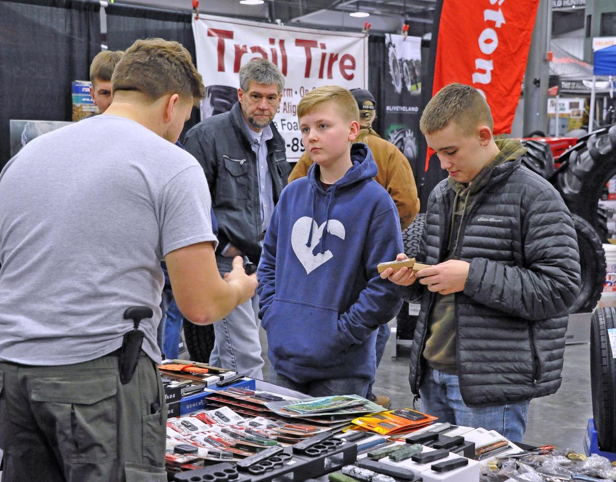 Bryan Crots of His Store and More shows Ayden Schafer and Josiah Walbom knives at the Northeast Ohio Sportsman Show on Thursday. The annual event continues today and Saturday in Mount Hope, featuring seminars, vendors and more.