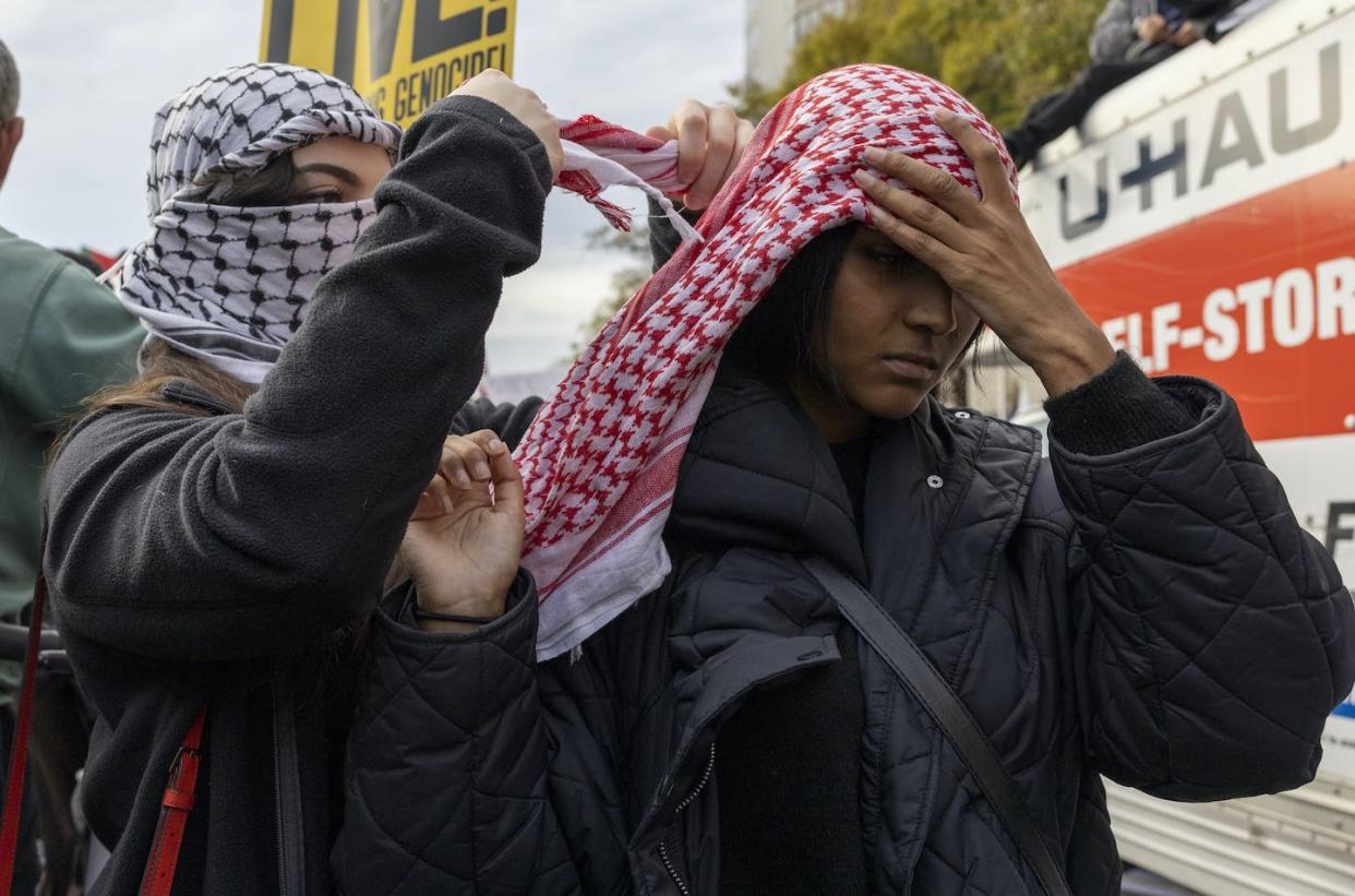 Two people use a Palestinian keffiyeh to show their support during a pro-Palestinian demonstration in Washington on Nov. 4, 2023. <a href="https://newsroom.ap.org/detail/USIsraelPalestinians/86773a62492842c8bc879695908b65c6/photo?Query=keffiyeh&mediaType=photo&sortBy=arrivaldatetime:desc&dateRange=Anytime&totalCount=238&currentItemNo=0" rel="nofollow noopener" target="_blank" data-ylk="slk:AP Photo/Amanda Andrade-Rhoades;elm:context_link;itc:0;sec:content-canvas" class="link ">AP Photo/Amanda Andrade-Rhoades</a>