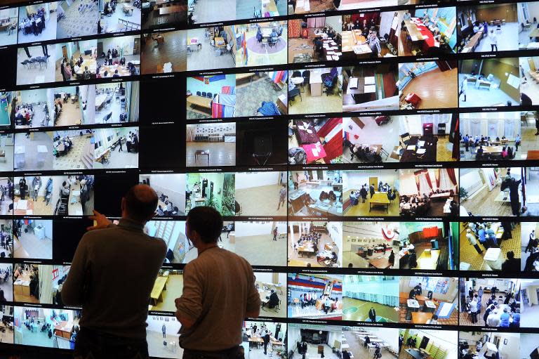 People look at screens broadcasting pictures from polling stations via a network of webcams at the headquarters of Russian Central Election Commission in Moscow on March 4, 2012