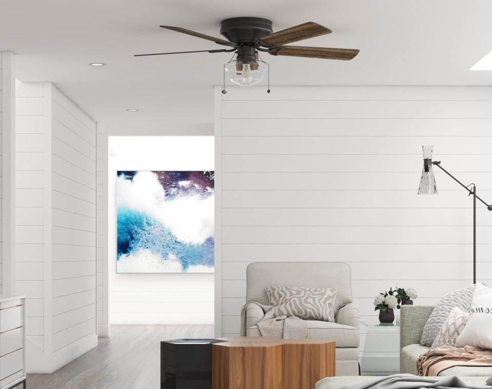 the bronze fan with a light bulb and two pull cords in a living room