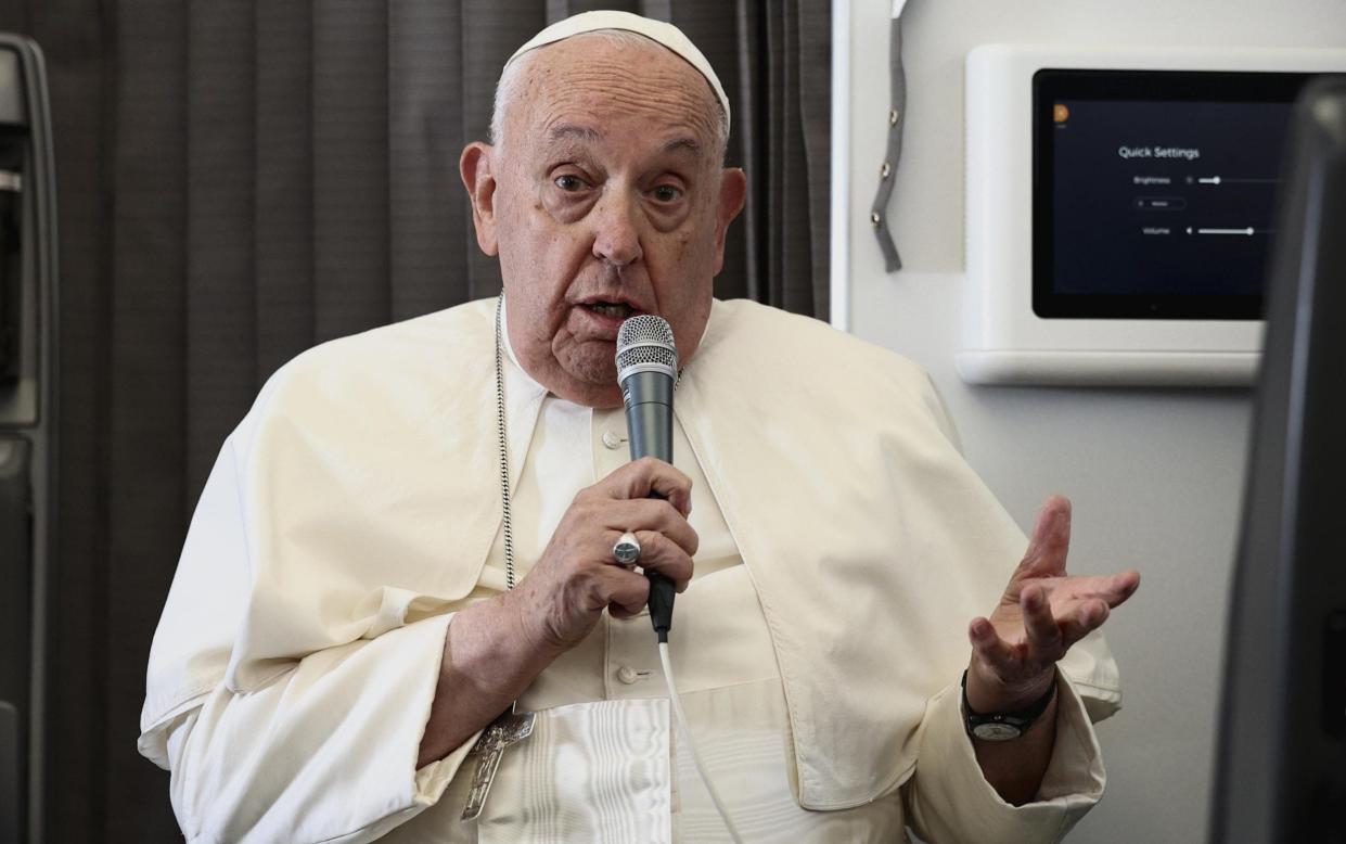 Pope Francis speaks on board his papal plane