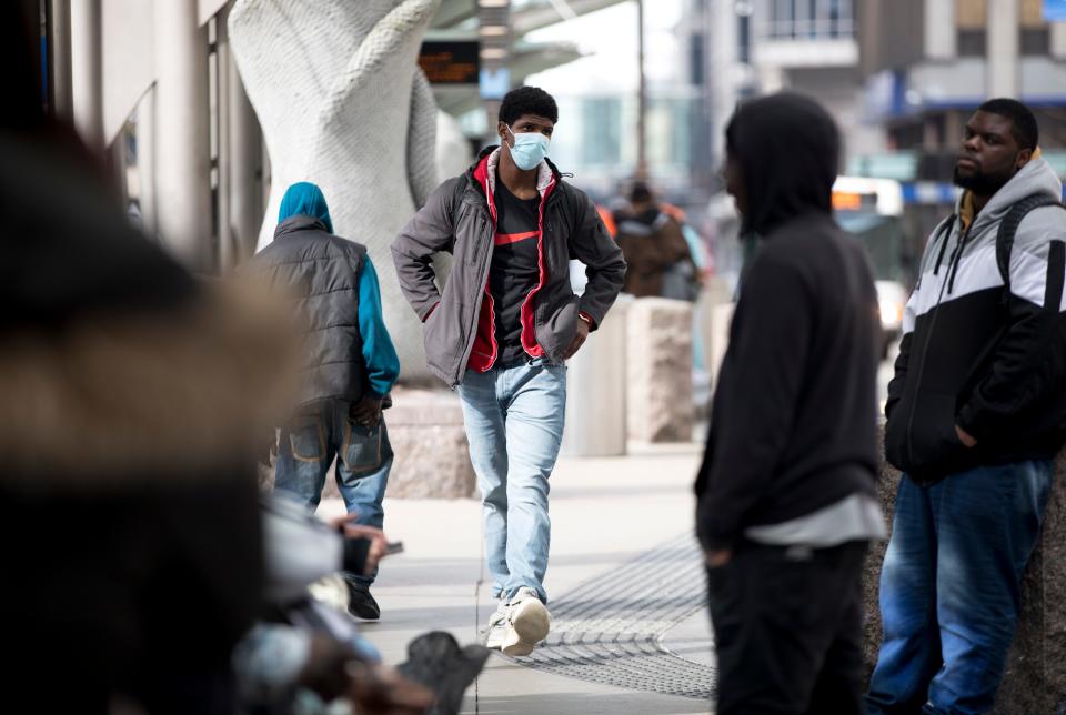 Mike Godby, of Finneytown, walks through the bus stop wearing a precautionary mask in downtown Cincinnati in March 2020, just days after the last leap day.