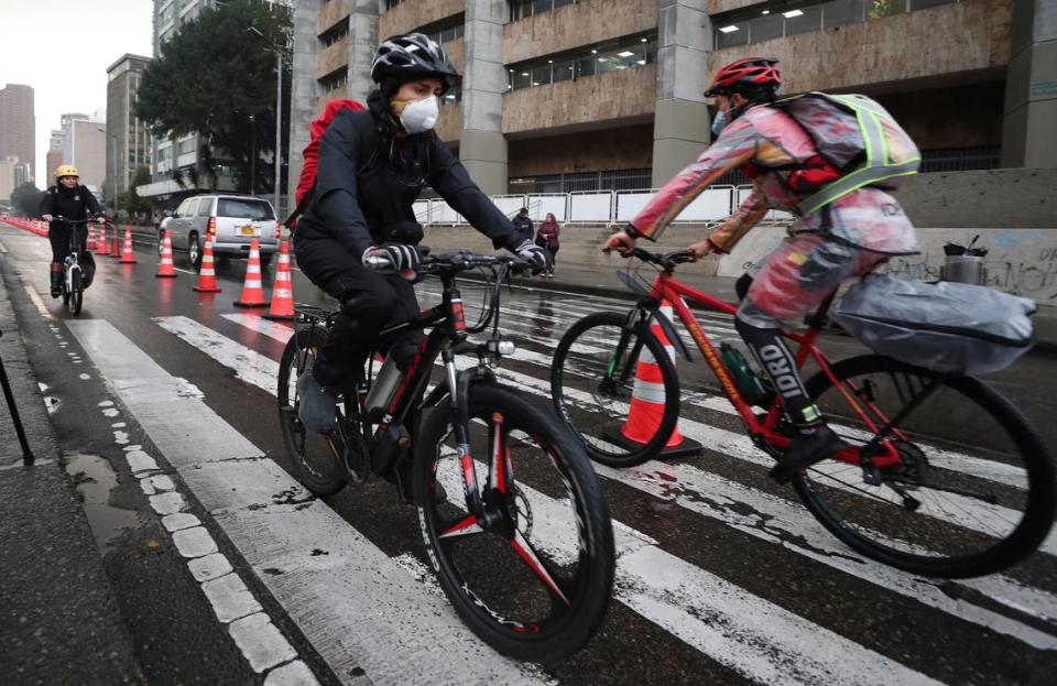 Commuters wearing protective masks ride their bicycles in Bogotá, Colombia, on March 16, 2020. Officials in Colombia’s capital have expanded bike routes, encouraging people to abandon crowded public transportation and lower their risk of catching the coronavirus.