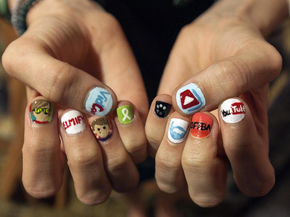 In this Thursday, June 28, 2012 photo, Kimmy Fiorentino, from North Carolina, shows her decorated nails with YouTube video channels at VidCon, the third annual conference and community gathering for online video at the Anaheim Convention Center in Anaheim, Calif. More than 6,000 people are expected to attend VidCon at the Anaheim Convention Center this weekend. (AP Photo/Damian Dovarganes)