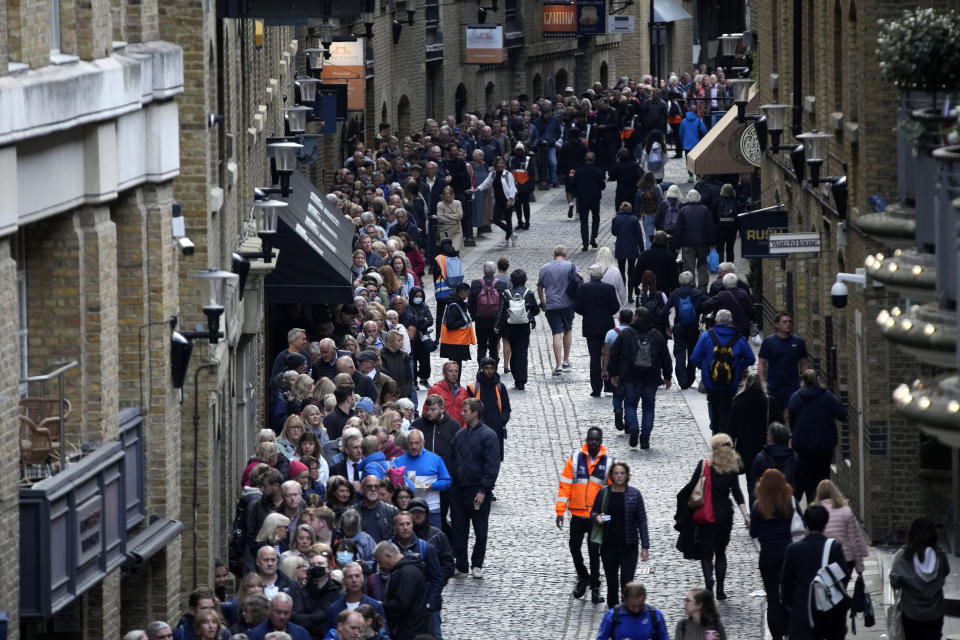FILE - People queue near Tower Bridge to pay their respects to the late Queen Elizabeth II who's lying in state at Westminster Hall in London, Friday, Sept. 16, 2022. Hotels, restaurants and shops are packed as royal fans pour into the heart of London to experience the flag-lined roads, pomp-filled processions and brave a mileslong line for the once-in-a-lifetime chance to bid adieu to Queen Elizabeth II. (AP Photo/Christophe Ena)