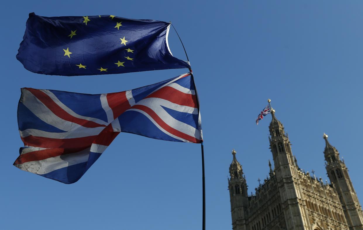 FILE - In this Wednesday, Feb. 27, 2019 file photo the flag of the European Union and the British national flag are flown on poles during a demonstration by remain in the EU outside spporters the Palace of Westminster in London. Britain's love-hate relationship with the rest of Europe goes back decades, but the Brexit crisis gripping it today stems from dramatic January 2013 speech by Prime Minister David Cameron in which he promised an "in or out" referendum. Britain voted to leave, but negotiations between Britain and the EU have been slow and at times acrimonious, and the 585-page withdrawal agreement produced after two years of talks has been rejected twice by Britain's divided Parliament. (AP Photo/Alastair Grant, File)