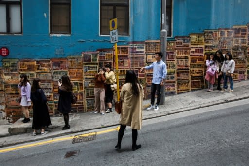 A mural by local graffiti artist Alex Croft featuring rows of tenement houses draws a constant stream of tourists to the steeply sloping Graham Street in downtown Central district