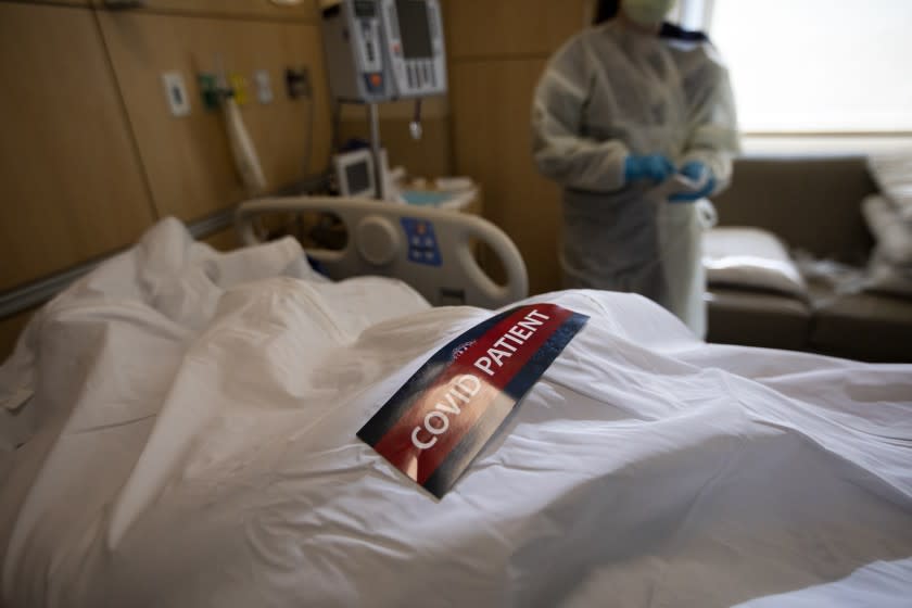 MISSION HILLS, CA - DECEMBER 31: A "covid patient" label and covid stickers have been placed on the white bag containing a deceased patient. Three people passed way this morning on this one hallway of complication of covid at Providence Holy Cross Medical Center on Thursday, Dec. 31, 2020 in Mission Hills, CA. "Simply in true 2020 fashion, the last day of the year sums up what this year has been like - truly awful. Today's experiences left me feeling defeated and conflicted about what it means to honor and respect those who are suffering, particularly at the end of life. I worry for those out there who journey alone through this unreal time.," says Palliative care physician Dr. Marwa Kilani, MD. (Francine Orr / Los Angeles Times)