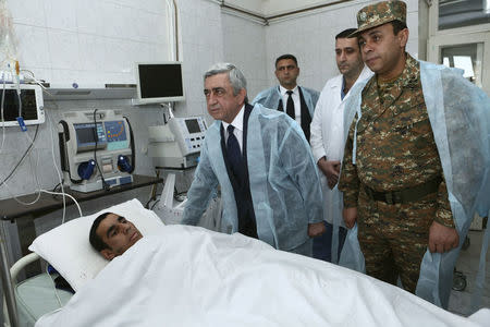 Armenian President Serzh Sargsyan (2nd L) visits a soldier, who was injured in clashes over the breakaway Nagorno-Karabakh region according to Armenian officials, at the Defence Ministry's central military hospital in Yerevan, Armenia, April 4, 2016. REUTERS/Hrant Khachatryan/PAN Photo