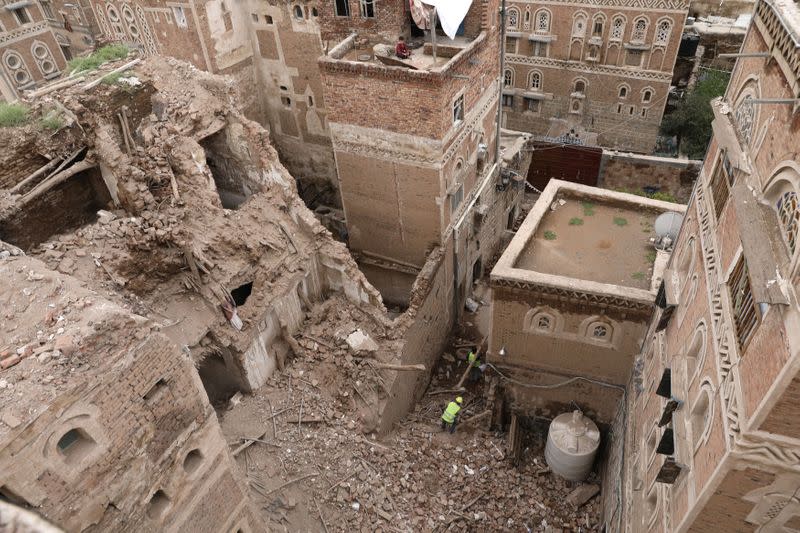 Workers demolish a building damaged by rain in the UNESCO World Heritage site of the old city of Sanaa