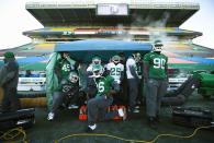 Saskatchewan Roughriders players stand under a heated tent during practice in Regina, Saskatchewan, November 22, 2013. The Saskatchewan Roughriders will play against the Hamilton Tiger-Cats in the CFL's 101st Grey Cup in Regina. REUTERS/Mark Blinch (CANADA - Tags: SPORT FOOTBALL)