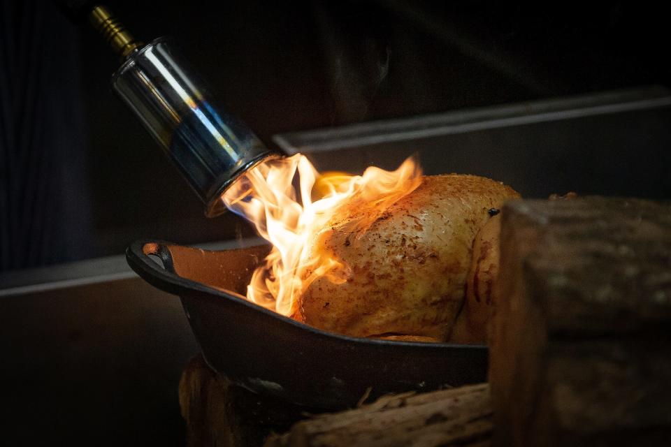 A smoked chicken is finished with a blowtorch flames at Tropical BBQ Market, a downtown West Palm spinoff of the city's popular Tropical Smokehouse.