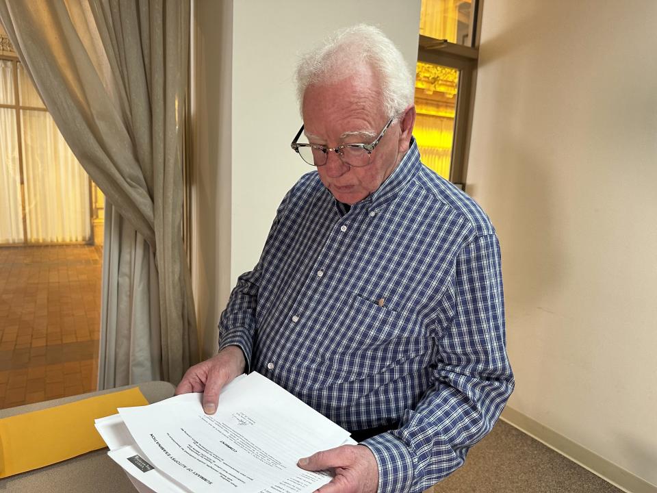 Michael Kruzich looks over his late mother's autopsy results Monday, April 15, 2024, in Lansing, Mich. Donna Kruzich was one of dozens of people in the U.S. who died after being injected with tainted steroids made by a specialty pharmacy in Massachusetts. Now, more than a decade later, the operator of the New England Compounding Center is returning to a Michigan court to be sentenced on involuntary manslaughter charges. (AP Photo/Mike Householder)