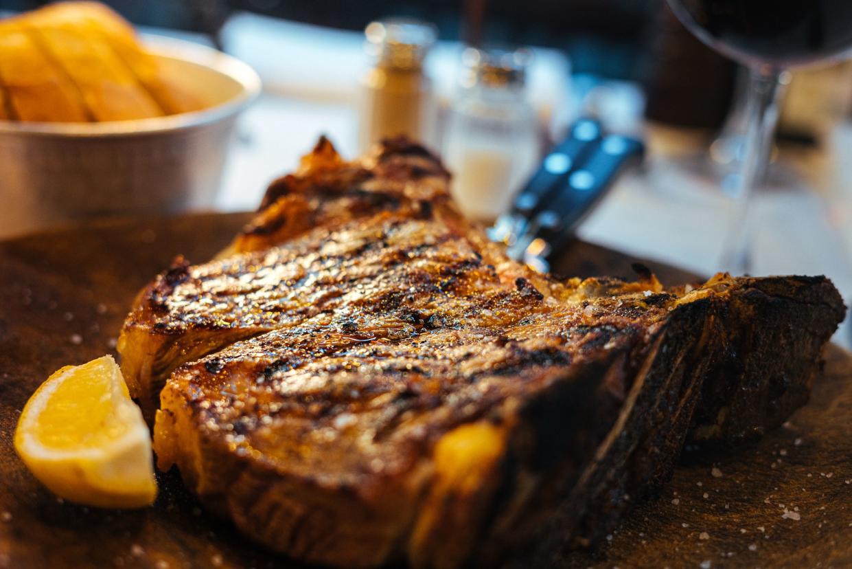 Close-Up Florentine T-Bone Steak and Lemon Wedge in Florence, Italy