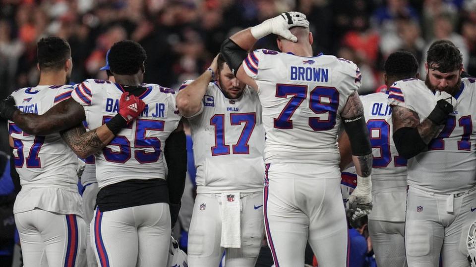 Jugadores de los Buffalo Bills acongojados mientras la ambulancia se lleva a su compañero Damar Hamlin.