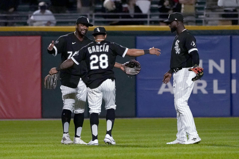 The Chicago White Sox outfielders Eloy Jimenez, Leury Garcia and Luis Robert, from left, celebrate the team's 9-3 win over the Los Angeles Angels in a baseball game Tuesday, Sept. 14, 2021, in Chicago. (AP Photo/Charles Rex Arbogast)