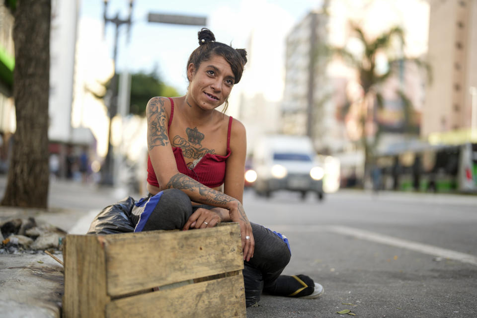 FILE - Alessandra Bueno Barros watches a performance by the clown doctor known as Flavio Falcone who works with drug addicts, in downtown Sao Paulo, Brazil, May 11, 2023. Bueno Barros applauds initiatives to change the area's dynamics, but said the future looks bleak. "There's no hope for anyone here, sir," Barros said. (AP Photo/Andre Penner, File)