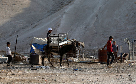 A Palestinian Bedouin boy rides a donkey in al-Khan al-Ahmar near Jericho in the occupied West Bank July 4, 2018. REUTERS/Mohamad Torokman