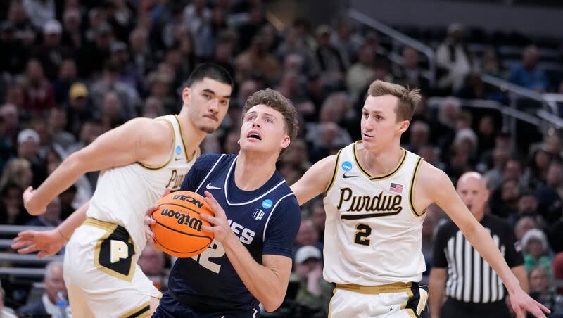 Utah State's Mason Falslev (12) heads to the basket past Purdue's Zach Edey and Fletcher Loyer (2) during the first half of a second-round college basketball game in the NCAA Tournament, Sunday, March 24, 2024 in Indianapolis. According to reports, Falslev has entered the NCAA transfer portal.